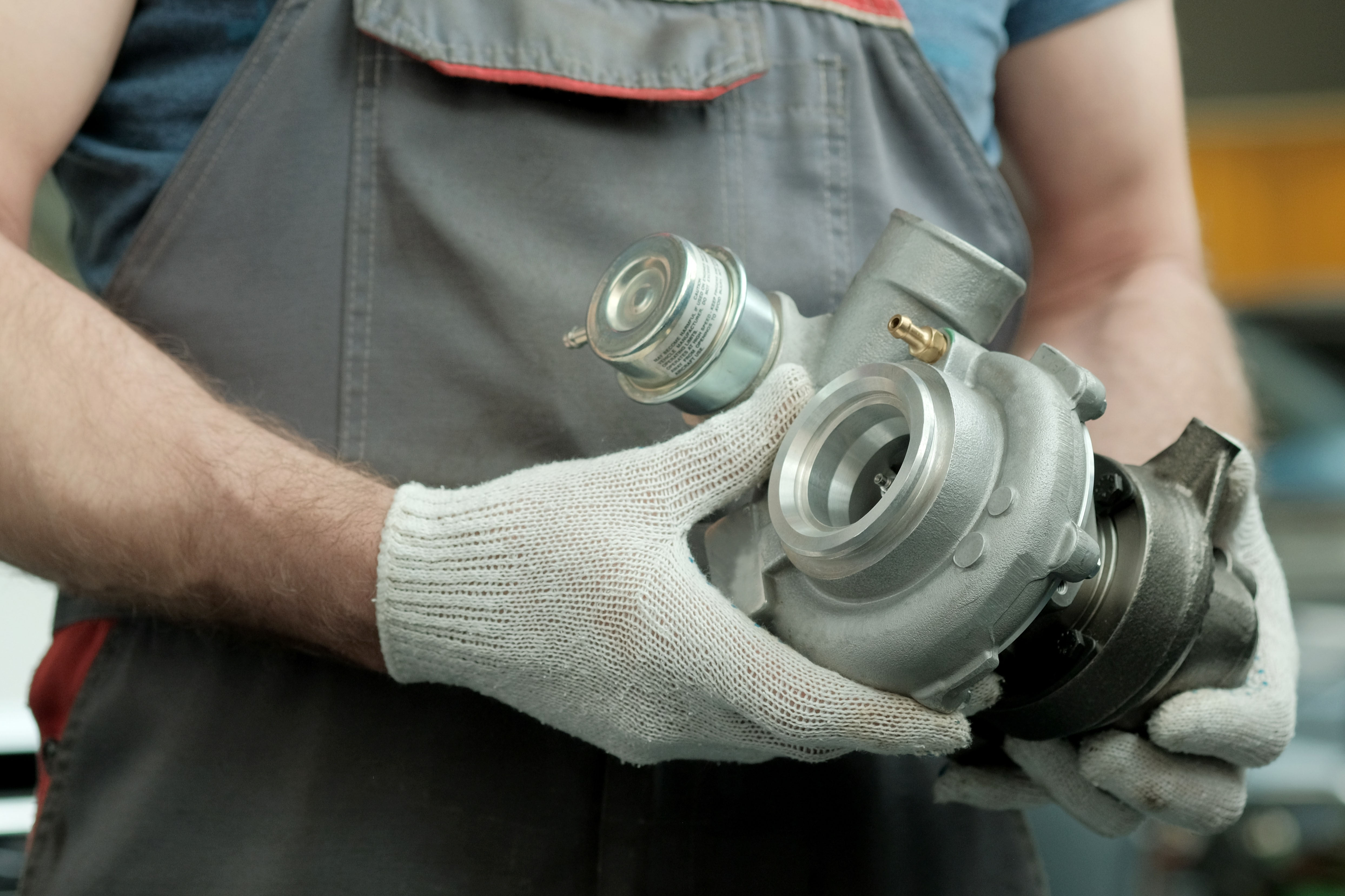Técnico sosteniendo un turbocompresor para inspección
